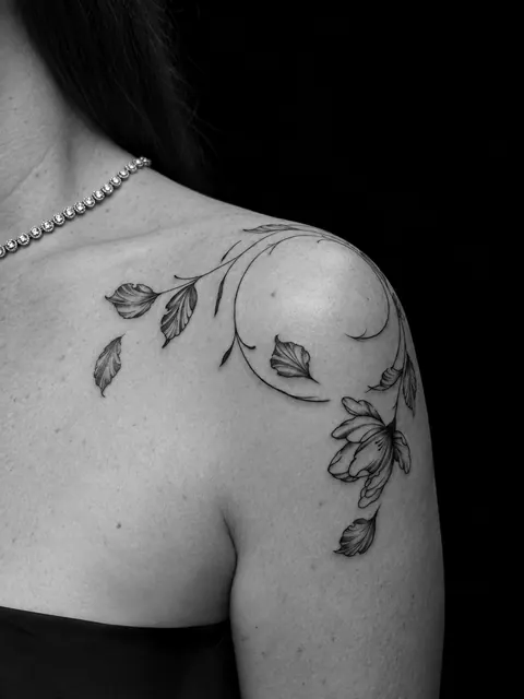 Enredadera fine line con hojas y una flor que rodea un hombro