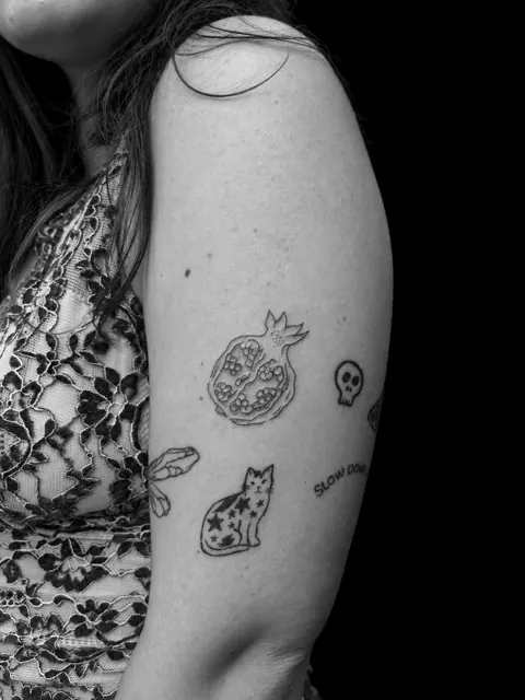 Tatuaje de una granada en tinta roja en la parte superior de un brazo