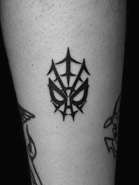 Tatuaje de una máscara neotribal en negro sólido en un gemelo
