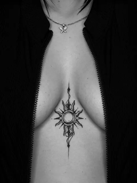 Tatuaje blackwork de un sol y una luna con sombreado de puntillismo a lo largo del esternón