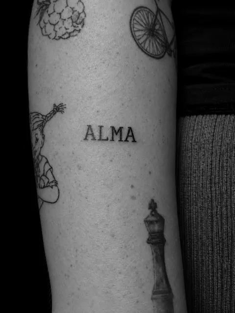 Palabra «ALMA» en mayúsculas con serifas en un antebrazo